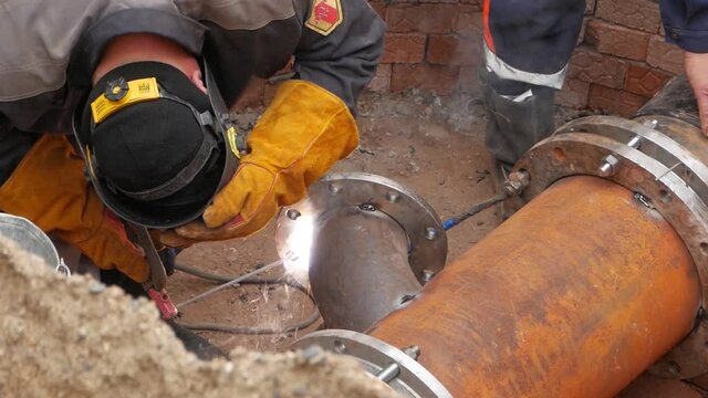 Welder worker welding pipe by electrode. close-up