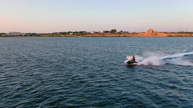 Water scooter on the sea into the sunset
