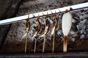 鮎の塩焼きと五平餅を炭火で焼いている風景