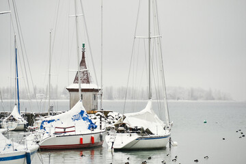 Boats in the harbor covered with snow during winter