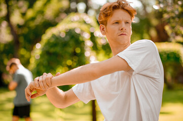 Guy doing warm-up in park on summer day