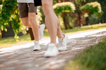 Male legs running along the park path
