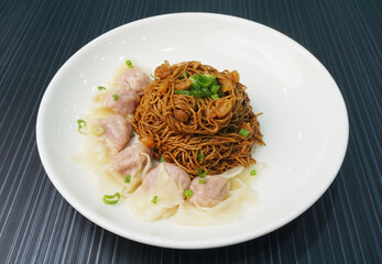 stir fried dry wanton noodle mee with meat dumpling on dark grey wood background dim sum halal menu