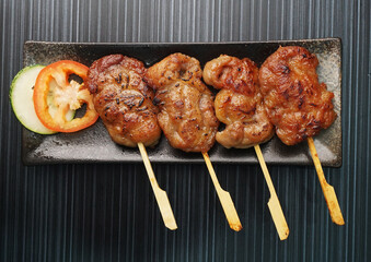 thai bbq grilled tender pork chop meat satay with sauce in plate on dark grey wood table asian dim sum halal food restaurant cuisine banquet menu for cafe