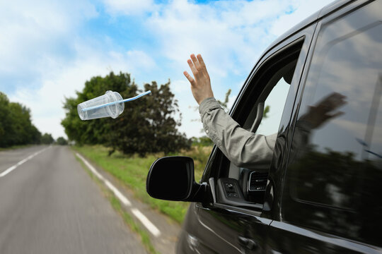 Driver Throwing Away Plastic Cup From Car Window. Garbage On Road