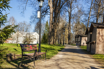Abramtsevo State Historical, Artistic and Literary Museum-Reserve. The alley of the manor park in early spring with beautiful wrought-iron benches. Abramtsevo, Moscow Region, Russia, May 2021