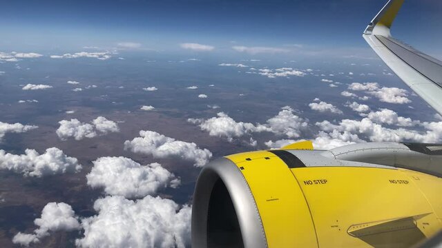 Airplane flight. Wing of an airplane flying above the clouds and sea in La Palma, Canary Islands. View from the window of the plane. 4K UHD