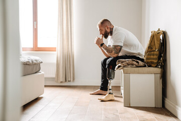 White military man with prosthesis siting on bench at home