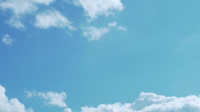 Low Angle view Time Lapse White Clouds in a Clear Serene Paradise Sky. Beautiful Background of Clear Sky and Cumulus White Clouds. Climate, Air Layer, Atmosphere, Paradise, Global Warming, Ecology.