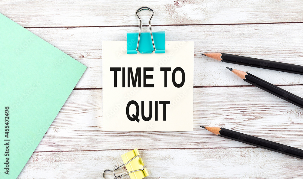 Poster stickers with pencils and notebook with text time to quit on wooden background