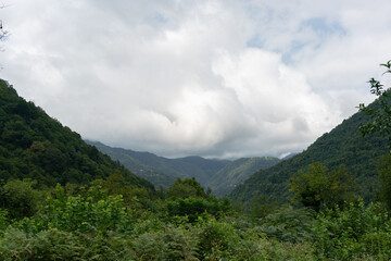 Behind the slopes of two wooded mountains
