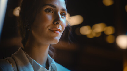 Beautiful Young Woman Walking Through Night City Street Full of Neon Lights and Entertainment Venues. Smiling Attractive Thoughtful Independent Woman Traveling. Close-up Portrait © Gorodenkoff