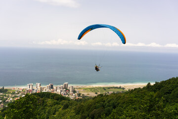 Two skydivers are flying over the mountain