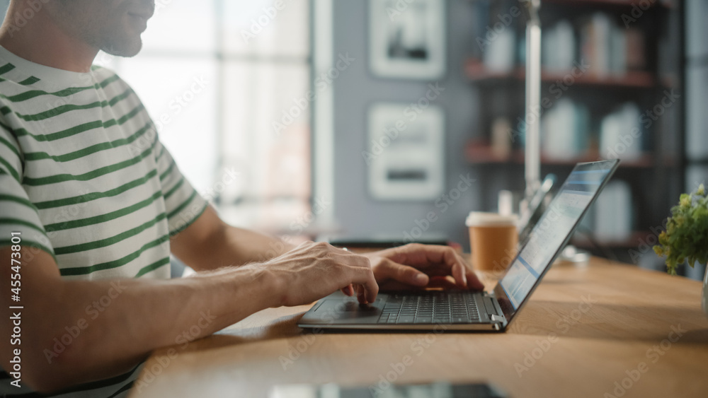 Poster portrait of handsome white man doing remote online work on laptop computer while sitting at his desk