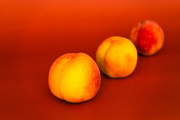 Installations of ripe peaches on a uniform background in various combinations. Healthy vegetarian food