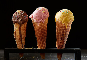 Three different creamy ice cream or gelato in sugar cones