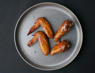 local charcoal bbq grilled honey golden chicken wing in plate on dark grey wood table asian dim sum...