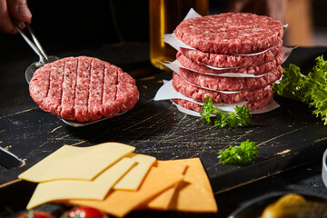 Freshly prepared ground beef burger patty on spatula