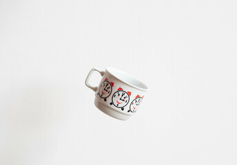 Mid-century modern porcelain mug with alarm clock pattern isolated, flying on white background