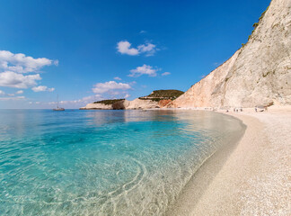White marble Porto Katsiki pebble beach tide with azure clear water. Close-up on coast of Lefkada island with steep cliffs in Greece. Summer vacation trip to Ionian Sea