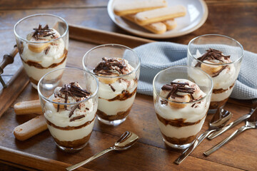 Glasses with Tiramisu dessert on table