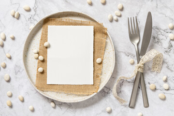 Blank paper card on a plate with little white stones
