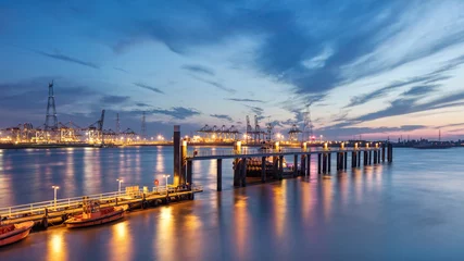 Rolgordijnen Pier in river Scheldt with container terminal on background at twilight, Port of Antwerp, Belgium. © tonyv3112