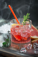 Fruit cocktail, in a glass with natural healthy fruits on a table with kitchen accessories.