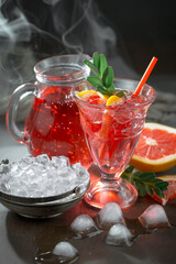 Fruit cocktail, in a glass with natural healthy fruits on a table with kitchen accessories.