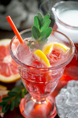 Cocktail in a glass with fruit on an old background.