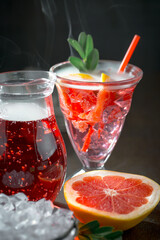 Fruit cocktail, in a glass with natural healthy fruits on a table with kitchen accessories.
