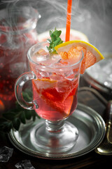 Fruit cocktail, in a glass with natural healthy fruits on a table with kitchen accessories.