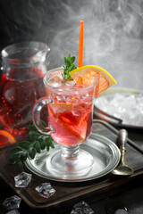 Cocktail in a glass with fruit on an old background.