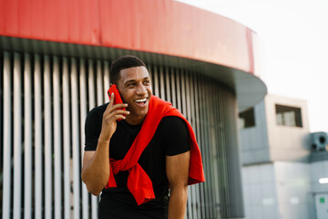 Black young man smiling while talking on cellphone