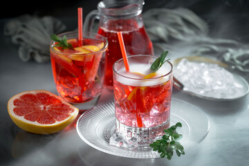 Fruit cocktail, in a glass with natural healthy fruits on a table with kitchen accessories.