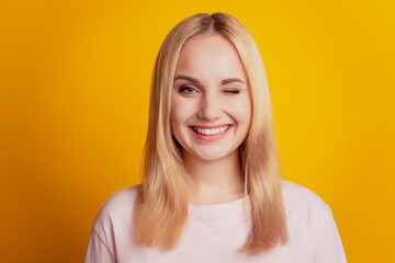 Portrait of coquette lovely lady blink eye toothy beaming smile on yellow background