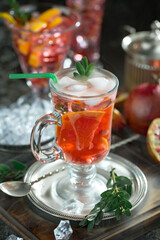 Fruit cocktail, in a glass with natural healthy fruits on a table with kitchen accessories.