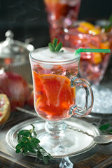 Fruit cocktail, in a glass with natural healthy fruits on a table with kitchen accessories.