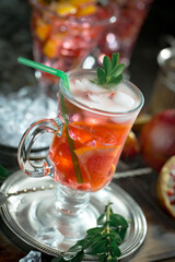 Fruit cocktail, in a glass with natural healthy fruits on a table with kitchen accessories.