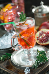Fruit cocktail, in a glass with natural healthy fruits on a table with kitchen accessories.