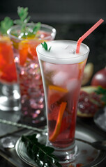 Fruit cocktail, in a glass with natural healthy fruits on a table with kitchen accessories.