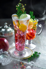 Fruit cocktail, in a glass with natural healthy fruits on a table with kitchen accessories.