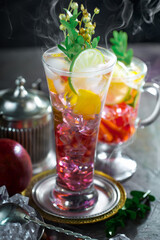 Fruit cocktail, in a glass with natural healthy fruits on a table with kitchen accessories.