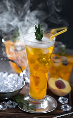 Fruit cocktail, in a glass with natural healthy fruits on a table with kitchen accessories.