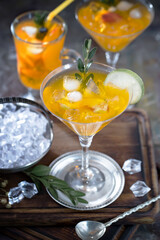 Fruit cocktail, in a glass with natural healthy fruits on a table with kitchen accessories.