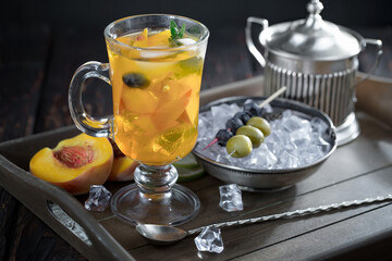Fruit cocktail, in a glass with natural healthy fruits on a table with kitchen accessories.
