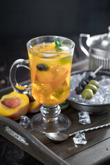 Fruit cocktail, in a glass with natural healthy fruits on a table with kitchen accessories.