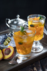 Fruit cocktail, in a glass with natural healthy fruits on a table with kitchen accessories.