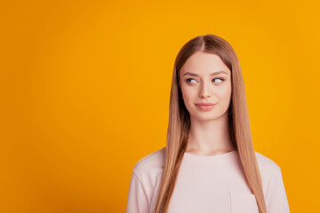 Portrait of positive curious lady look side empty space on yellow background