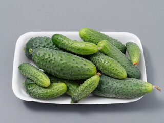 agricultural products green prickly cucumber on gray background